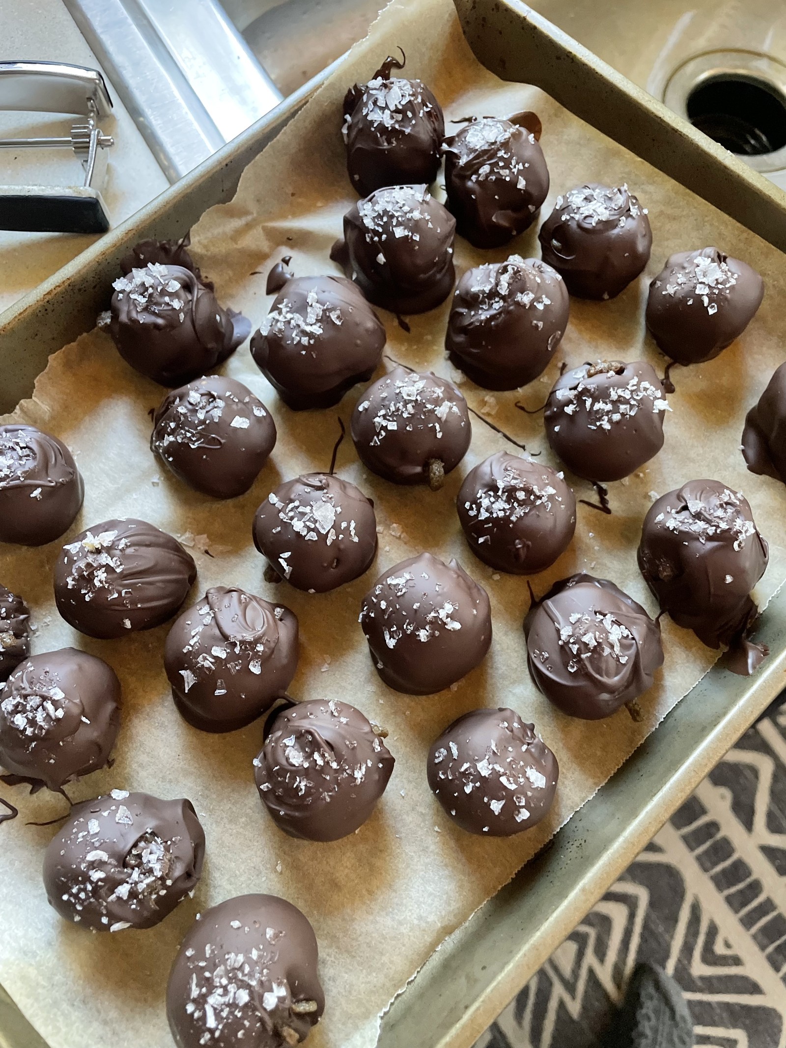 Freshly dipped dark chocolate truffles resting on parchment
